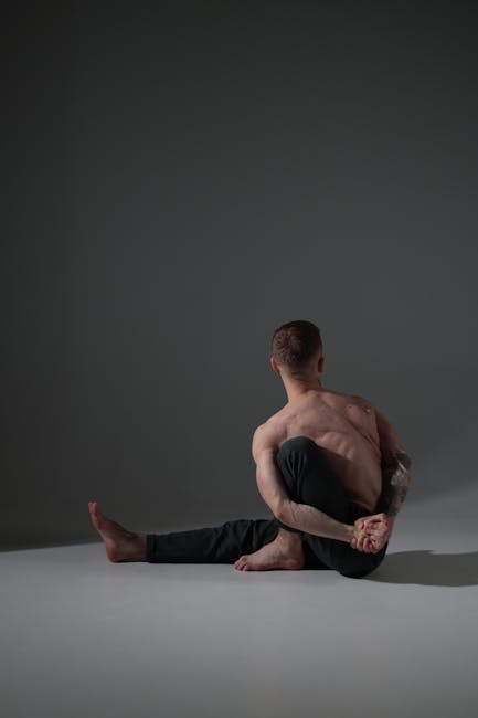 A man practices yoga in a modern apartment, focusing on a stretching pose.